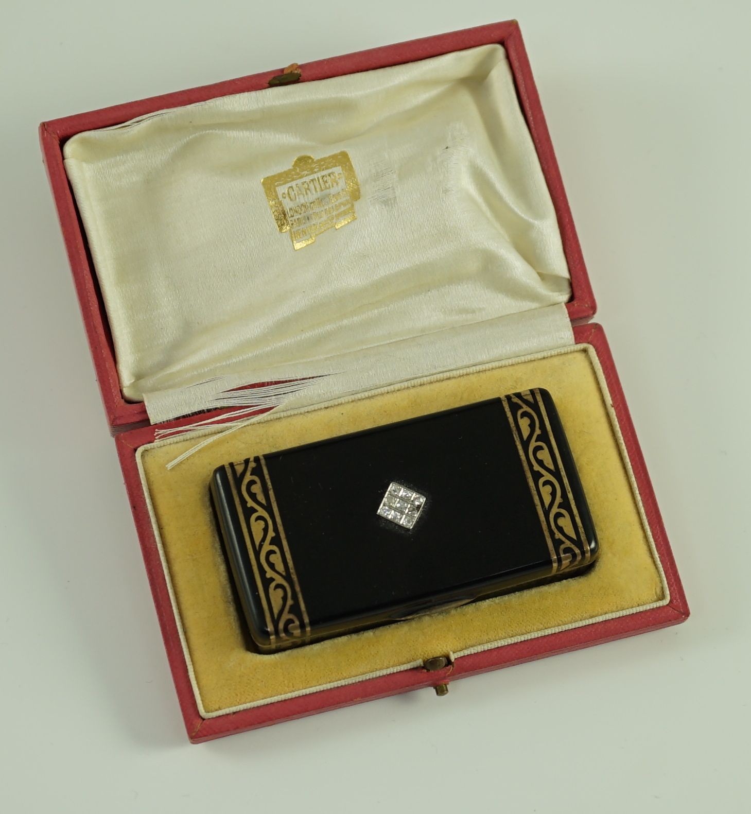 A late 1920's French Cartier silver gilt, black enamel and diamond set snuff box, in fitted gilt tooled leather Cartier box